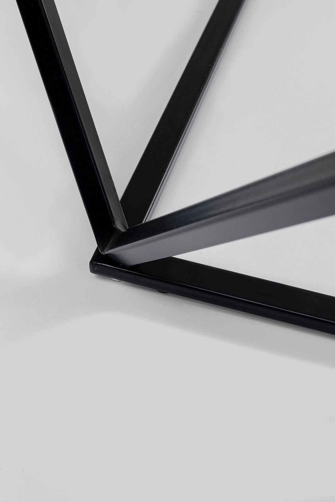 Nahaufnahme eines schwarzen Metallgestells eines Beistelltisches aus der Vogelperspektive.