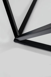 Nahaufnahme eines schwarzen Metallgestells eines Beistelltisches aus der Vogelperspektive.