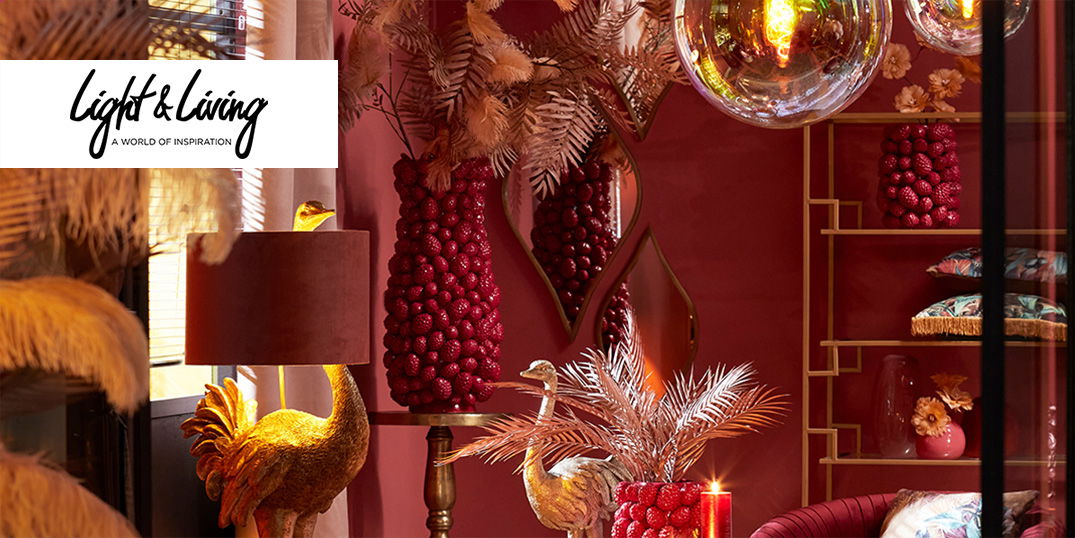 Ein Raum in Rot- und Goldtönen mit Deko-Vasen, goldenen Tieren und gemütlichem Licht.