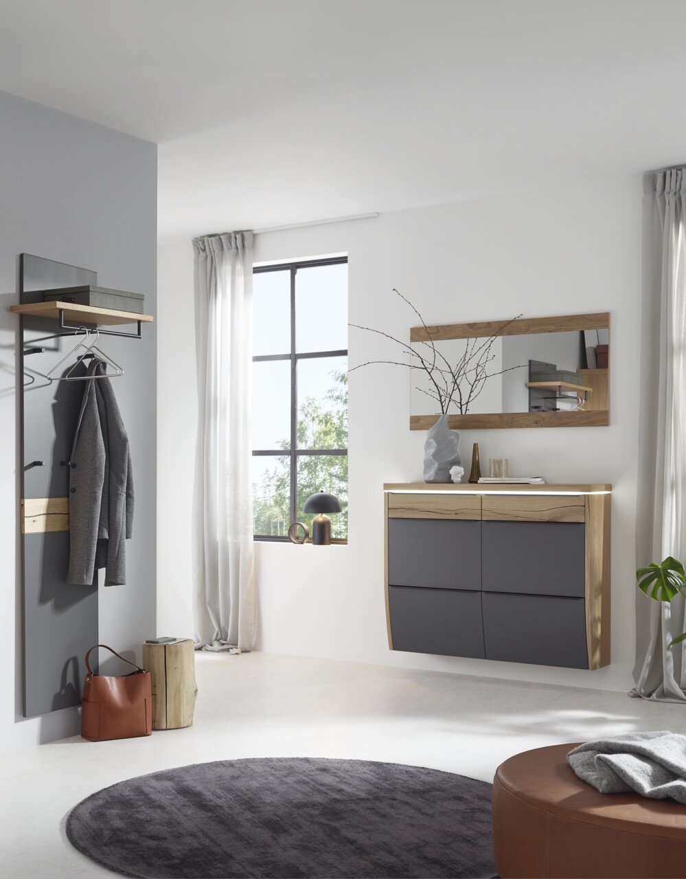 Modernes Flur-Set mit wandhängender Kommode in Anthrazit und Holzoptik, passendem Wandspiegel und Garderobenpaneel mit Kleiderstange und Haken, frontal in heller Raumszene aufgenommen.
