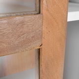 Nahaufnahme einer Vitrine aus hellem Holz mit Glasfront, seitliche Perspektive.