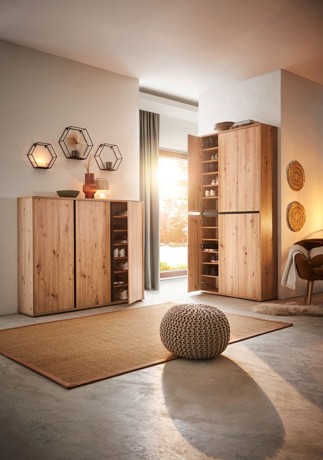 Schuhschrank aus Holz in einem modernen Wohnzimmer, mit geöffneter Tür, die mehrere Regale mit Schuhen zeigt. Perspektive von vorne links.