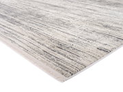 Designer Teppich in Grau- und Beigetönen mit Streifenmuster, perspektivisch von der Seite fotografiert