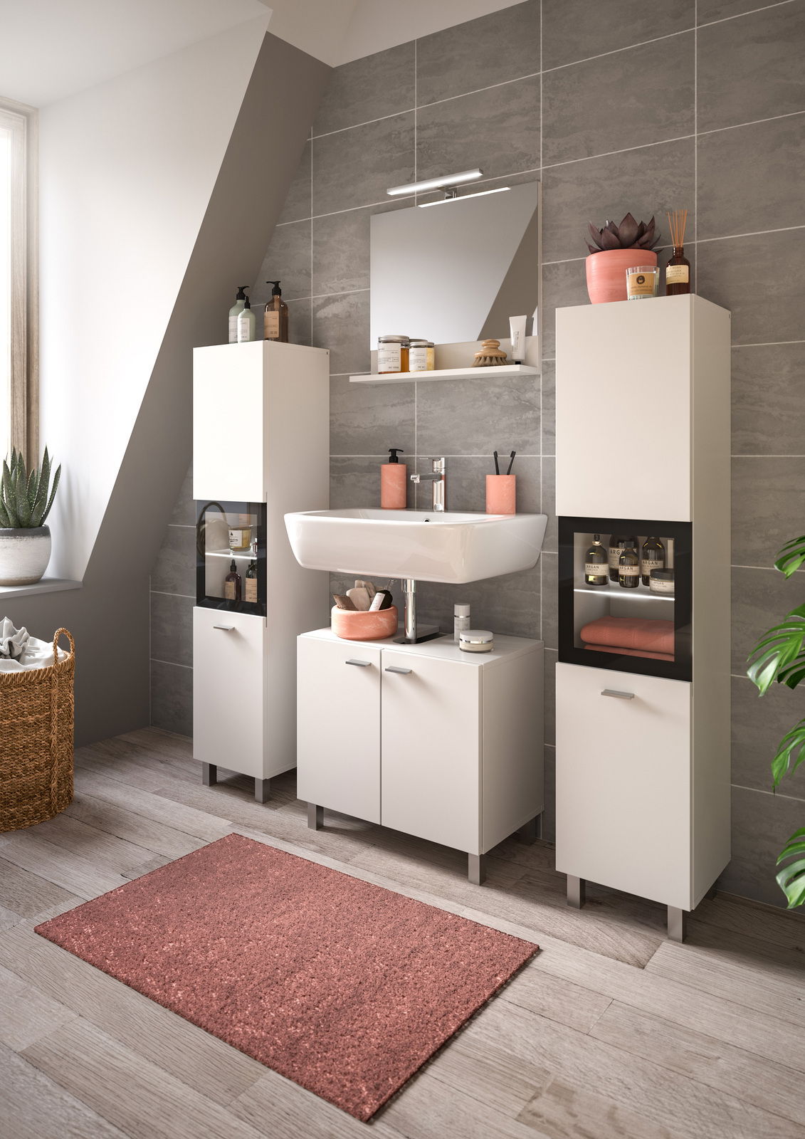 Moderne Badkombination BOSTON mit zwei hohen Schränken, Waschbecken und Spiegel in einem stilvollen Badezimmer mit grauen Fliesen und natürlichem Licht von der Seite.