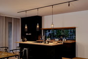 Moderne Küche mit drei hängenden Dekoschirmen Biraha in einem eleganten, minimalistischen Design. Perspektive von der Seite, die die gesamte Kücheninsel und die Hängelampen zeigt.