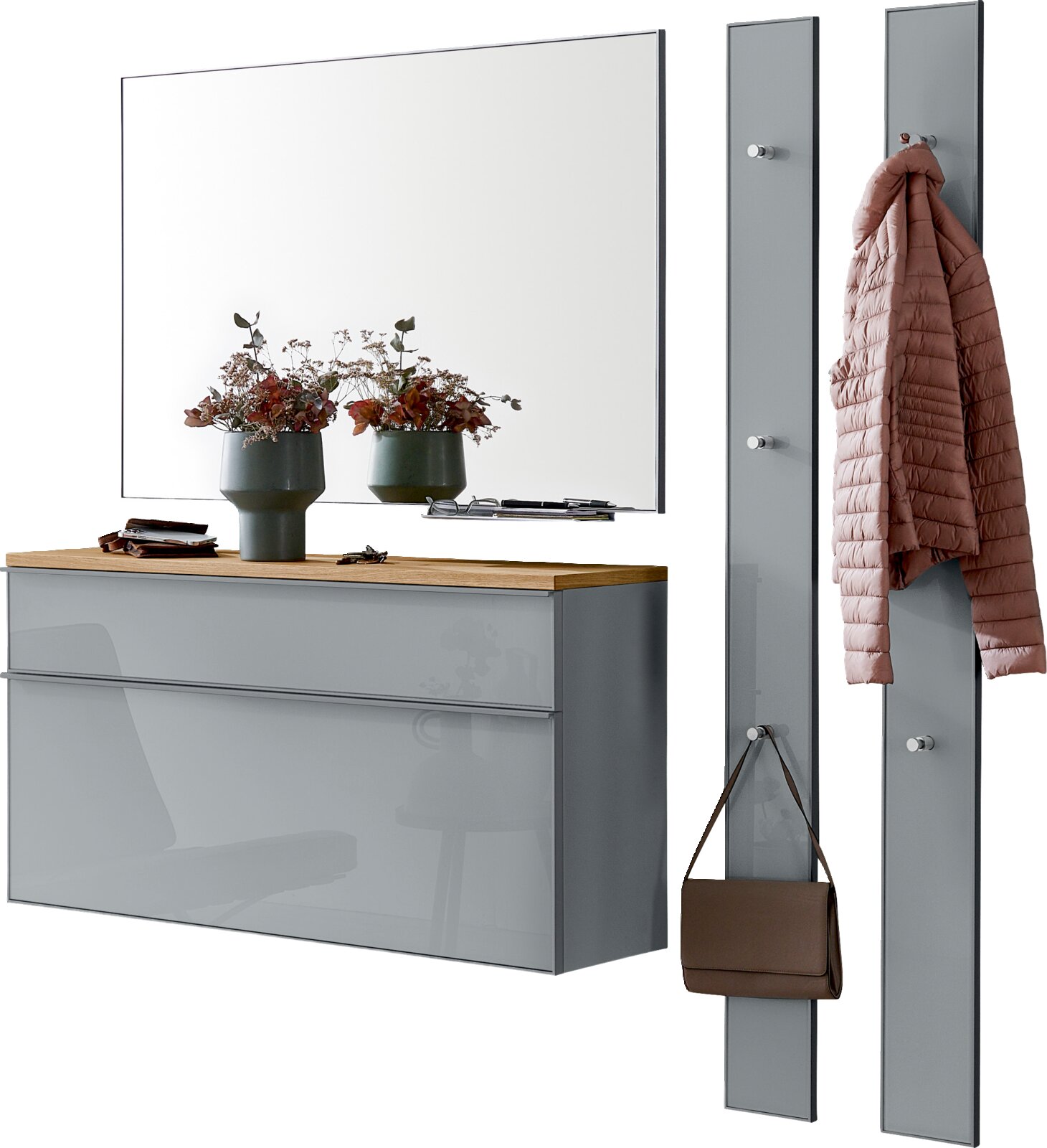 Modernes Flur-Set mit großem Wandspiegel über grauer Hochglanz-Kommode mit Holzablage sowie zwei grauen Garderobenpaneelen mit Haken, Jacke und Tasche, Ansicht schräg von vorn