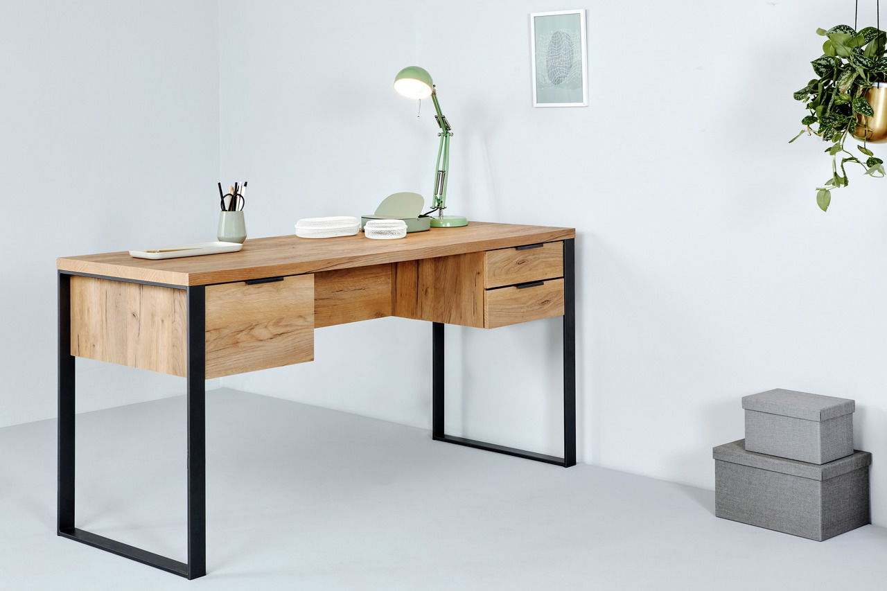 Moderner Schreibtisch aus Holz mit schwarzen Metallbeinen, seitliche Perspektive, dekoriert mit einer grünen Lampe und Schreibutensilien.