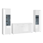 Wohnkombination in Weiß mit zwei hohen Vitrinen und einem Sideboard, frontal betrachtet.