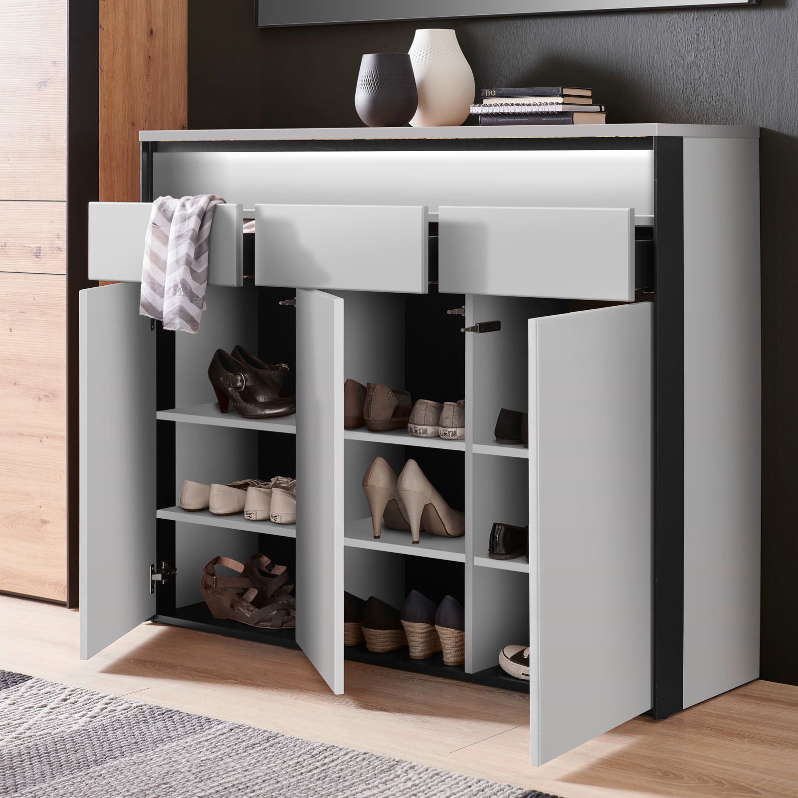 Moderner XL-Schuhschrank mit offenen Türen und Schubladen, gefüllt mit verschiedenen Schuhen, aus der Vorderansicht.