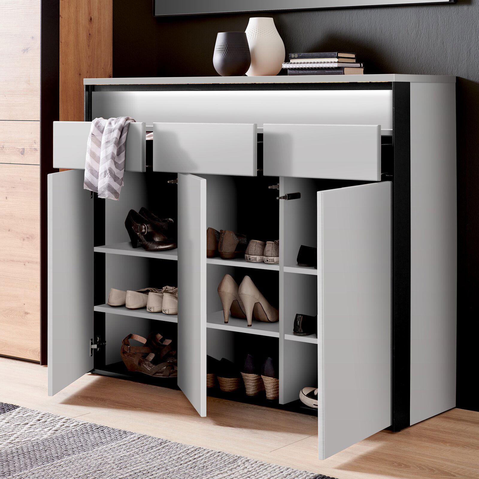 Moderner XL-Schuhschrank mit offenen Türen und Schubladen, gefüllt mit verschiedenen Schuhen, aus der Vorderansicht.