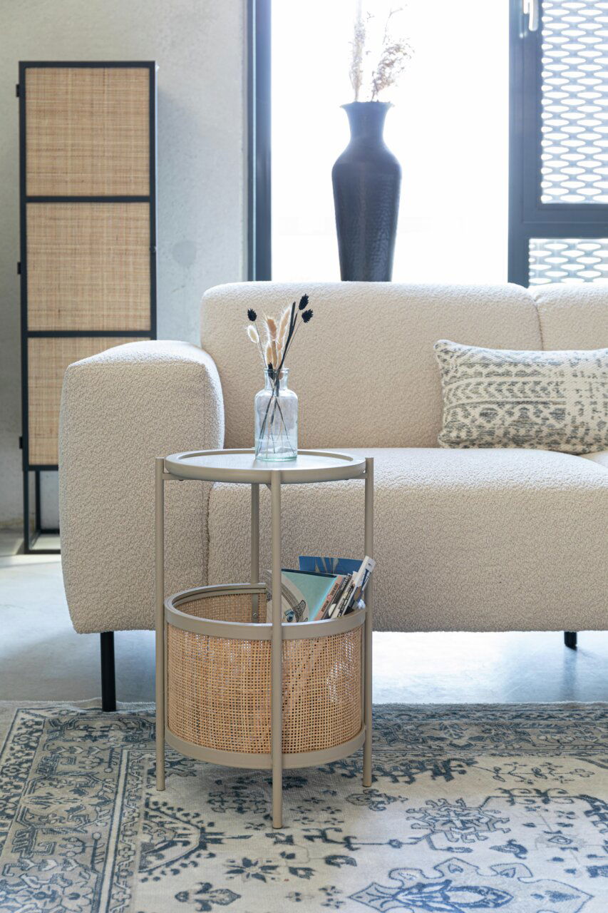 Z2 Beistelltisch MAKATO Beistelltisch mit rundem Tablett und Korb, seitliche Perspektive, neben einem Sofa in einem modernen Wohnzimmer.
