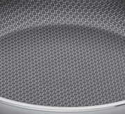 Nahaufnahme der Innenfläche einer Servierpfanne mit hexagonalem Muster, Perspektive von oben.