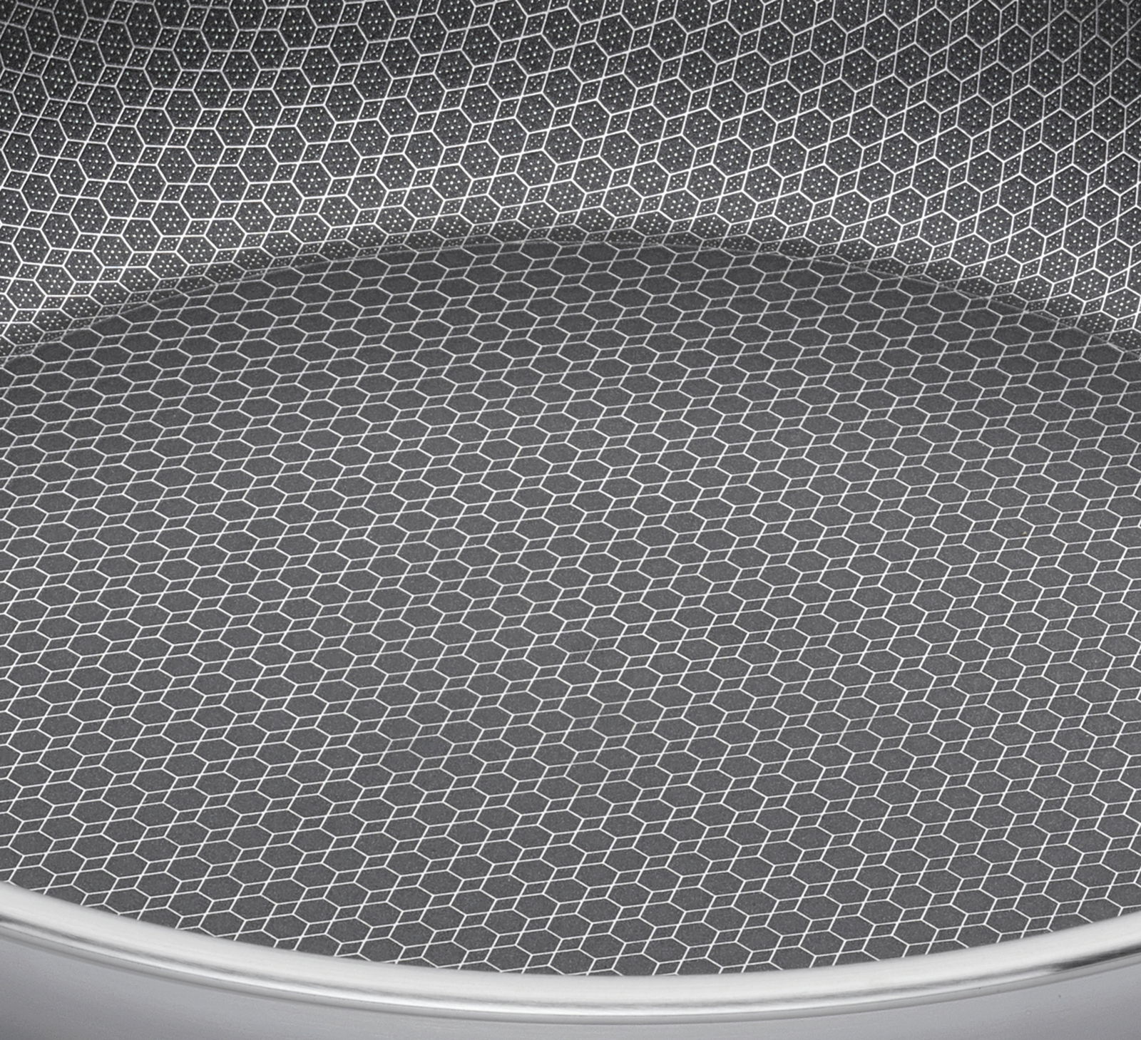 Nahaufnahme der Innenfläche einer Servierpfanne mit hexagonalem Muster, Perspektive von oben.