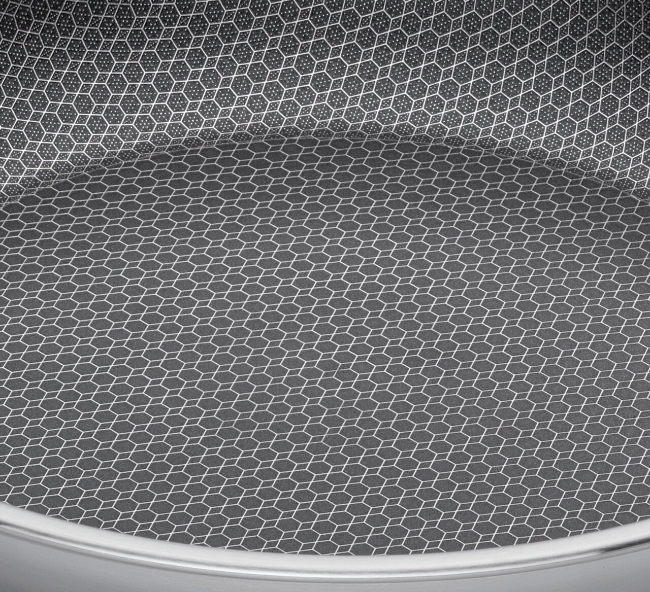 Nahaufnahme der Innenfläche einer Servierpfanne mit hexagonalem Muster, Perspektive von oben.