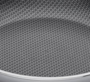 Nahaufnahme der Innenfläche einer Servierpfanne mit hexagonalem Muster, Perspektive von oben.