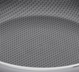 Nahaufnahme der Innenfläche einer Servierpfanne mit hexagonalem Muster, Perspektive von oben.