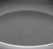 Nahaufnahme der Innenfläche einer Servierpfanne mit hexagonalem Muster, Perspektive von oben.