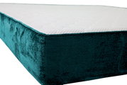 Close-up van een gestoffeerd bed met donkergroene bekleding, gezien vanaf de zijkant
