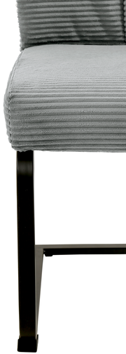 Nahaufnahme eines grauen Schwingstuhls mit geripptem Stoffbezug und schwarzem Metallgestell, seitliche Perspektive