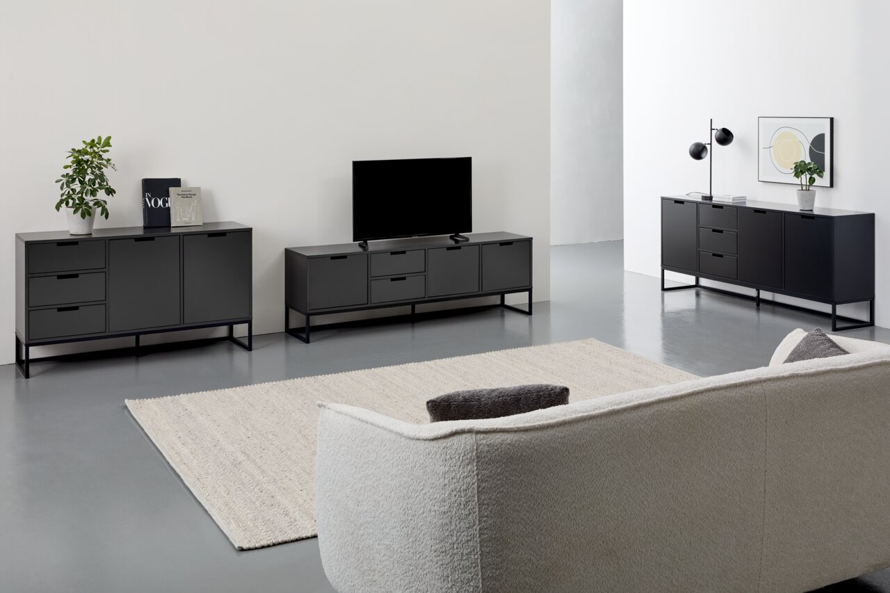 Novel Sideboard KUNO Moderne schwarze Sideboards und TV-Lowboard in einem minimalistischen Wohnzimmer, seitliche Perspektive.