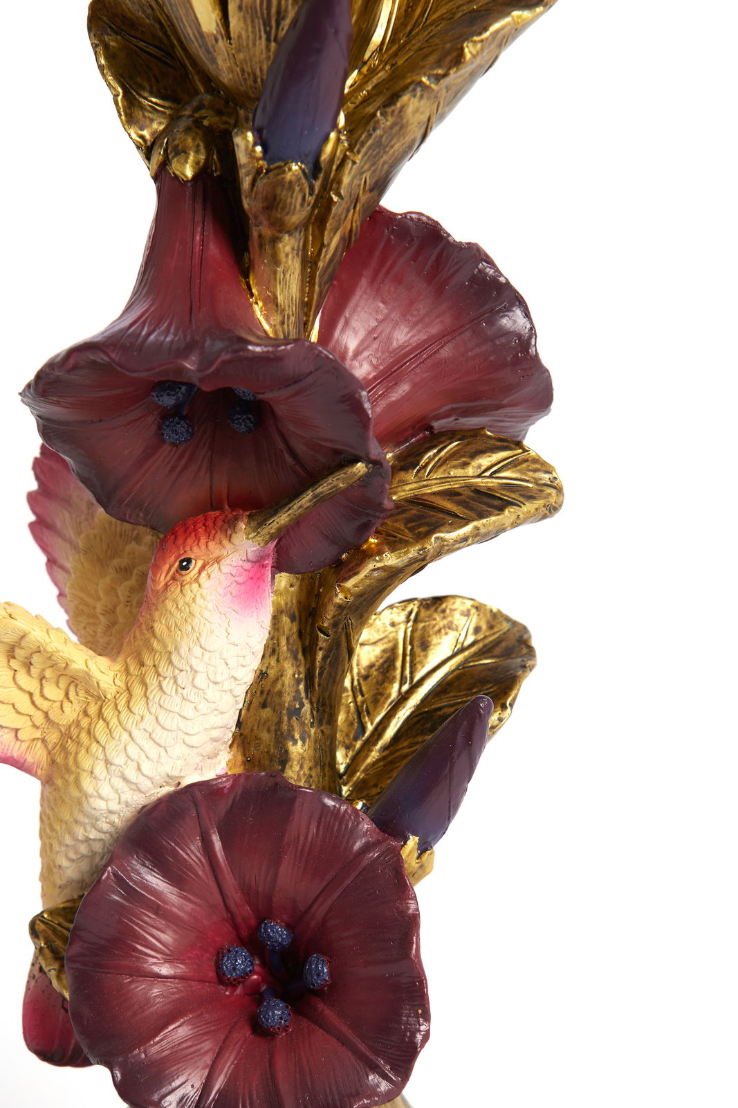 Detailansicht eines kunstvollen Kerzenständers mit goldenen Blättern, roten Blüten und einem dekorativen Vogel.