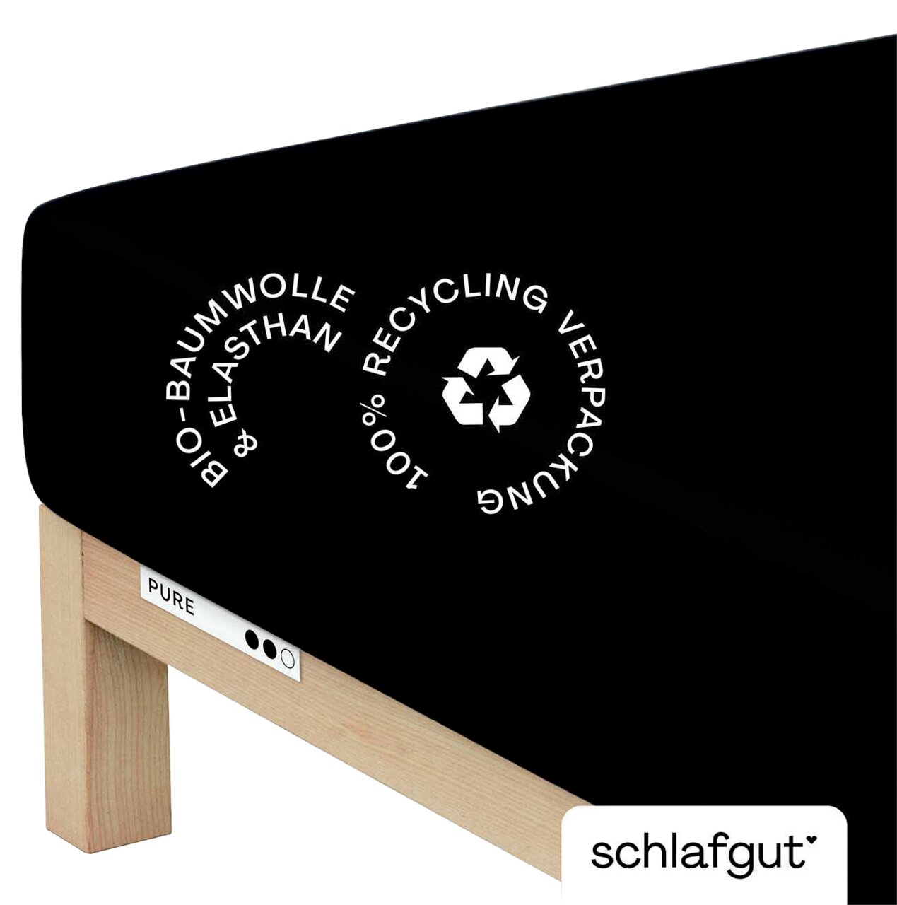 Schwarzes Spannbettlaken aus Bio-Baumwolle und Elasthan auf einer Matratze, mit Hinweis auf 100% recycelte Verpackung, seitliche Perspektive.