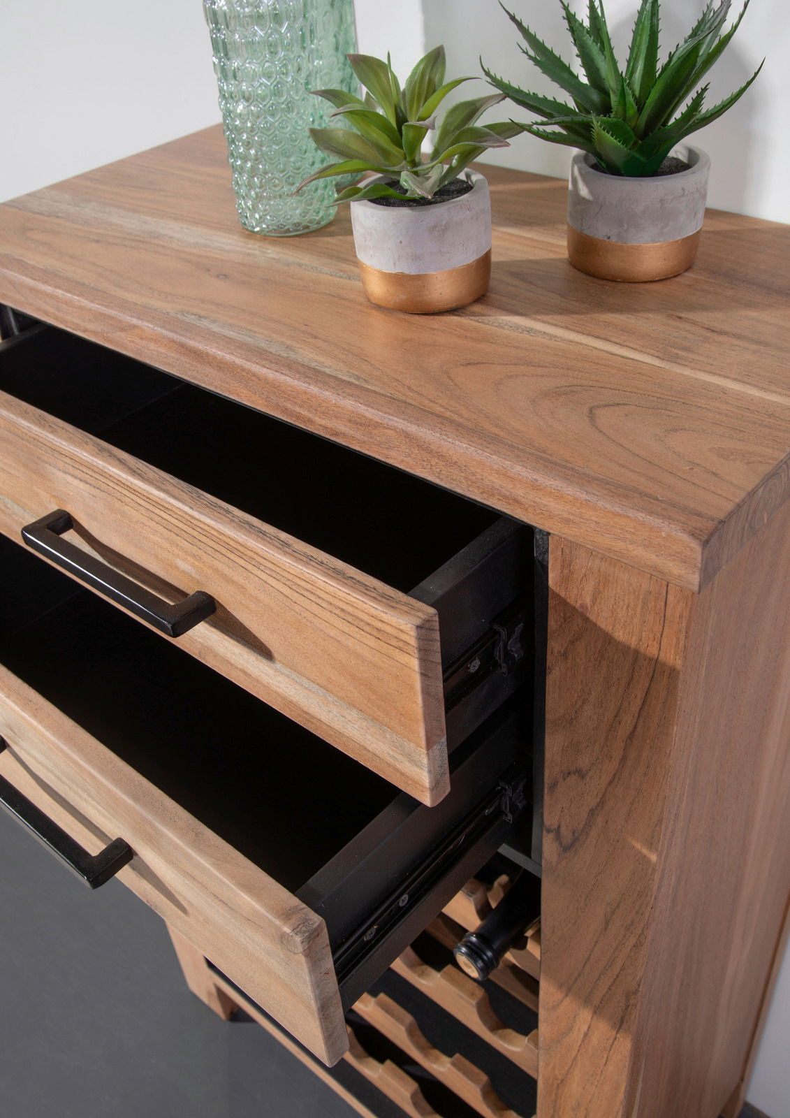 Weinregal aus Holz mit zwei offenen Schubladen, dekoriert mit Pflanzen und Glasvase, aus der Vogelperspektive