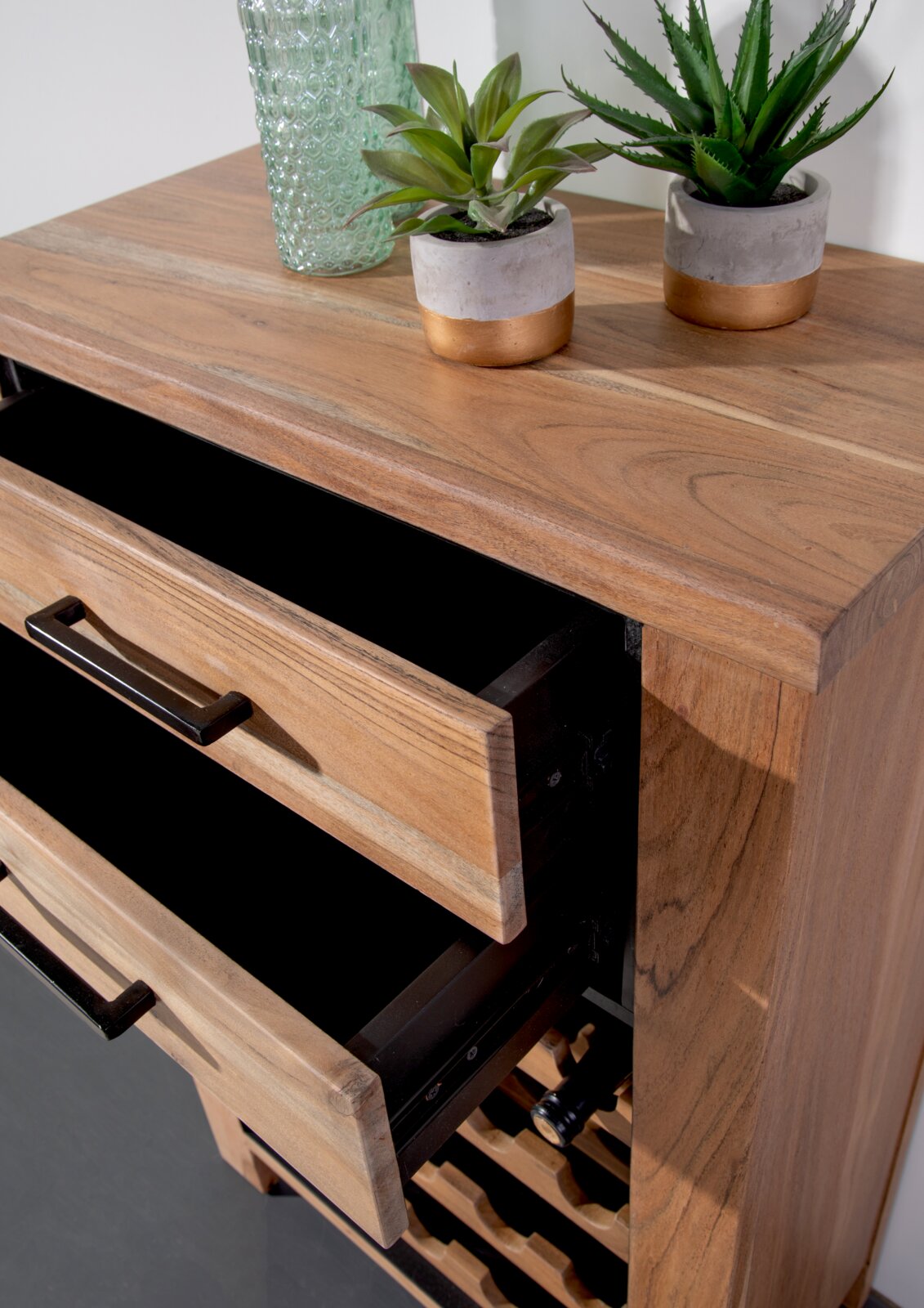Houten wijnrek met twee open lades, versierd met planten en een glazen vaas, gezien vanuit vogelperspectief