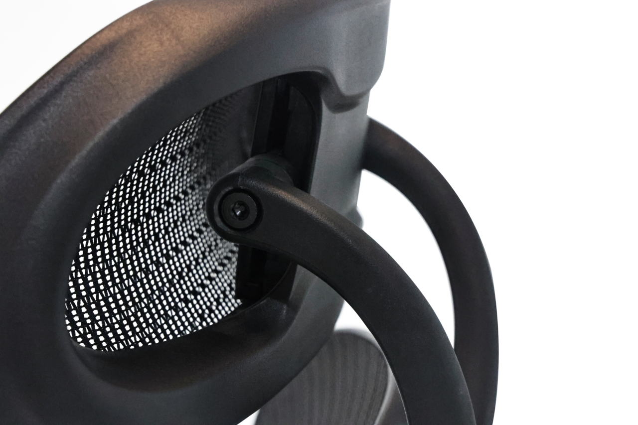 Nahaufnahme der Rückseite eines Drehstuhls mit schwarzem Netzrücken und Armlehne, seitliche Perspektive.