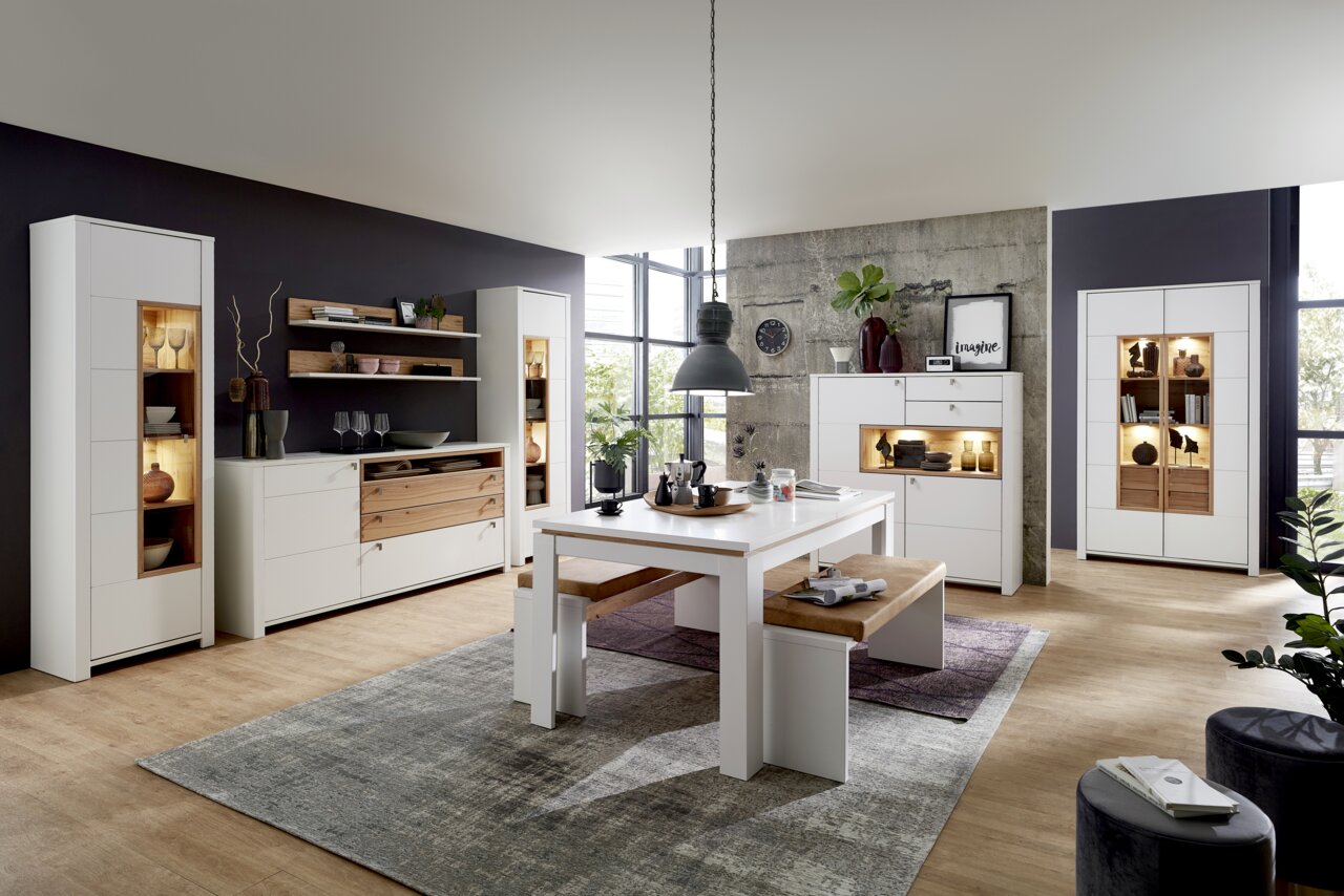 Moderne Wohnzimmermöbel in heller Holzoptik mit Vitrinen, Sideboard, Esstisch und Bank, seitliche Perspektive