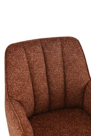 Nahaufnahme eines braunen Armlehnstuhls mit gepolsterter Rückenlehne, von vorne betrachtet.