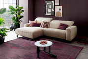 Beiges Cord-Ecksofa mit linker Ottomane und schwarzen Metallfüßen in modernem Wohnzimmer, aufgenommen in schräger Frontansicht von links.