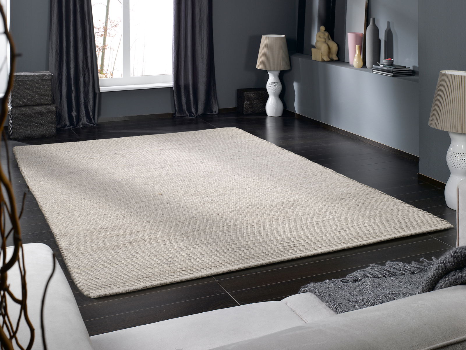 Handgewebter Teppich in einem modernen Wohnzimmer, aus der Perspektive eines Sofas fotografiert.