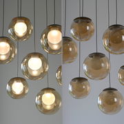 Moderne LED-Pendelleuchte mit mehreren kugelförmigen, transparenten Lampenschirmen, von unten betrachtet.