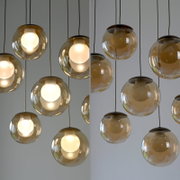 Moderne LED-Pendelleuchte mit mehreren kugelförmigen, transparenten Lampenschirmen, von unten betrachtet.