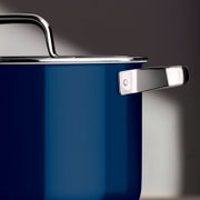 Close-up van een blauwe kookpan met roestvrijstalen handvat en deksel, zijaanzicht