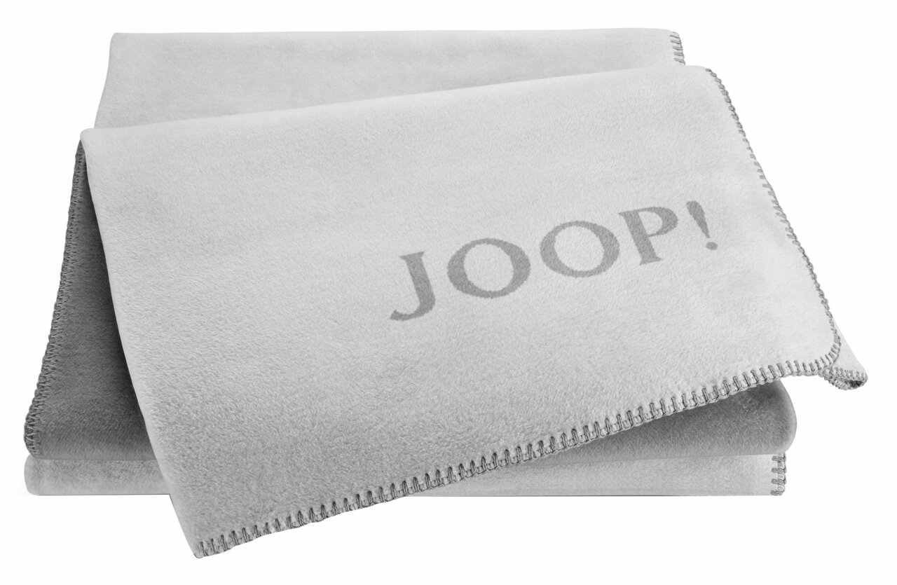 JOOP! Wohndecke UNI-DOUBLEFACE - grau Graue Decke mit JOOP!-Logo, gefaltet und von oben fotografiert.