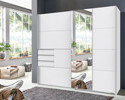 Moderner weißer Schwebetürenschrank mit Spiegel, frontale Ansicht in einem hellen Raum mit großen Fenstern.