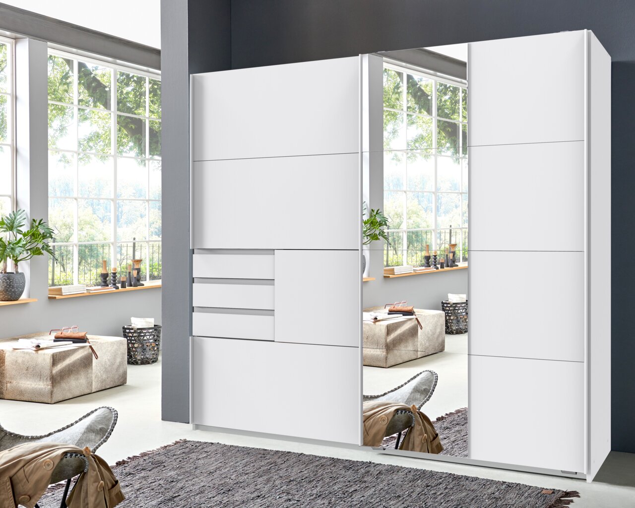 Moderner weißer Schwebetürenschrank mit Spiegel, frontale Ansicht in einem hellen Raum mit großen Fenstern.