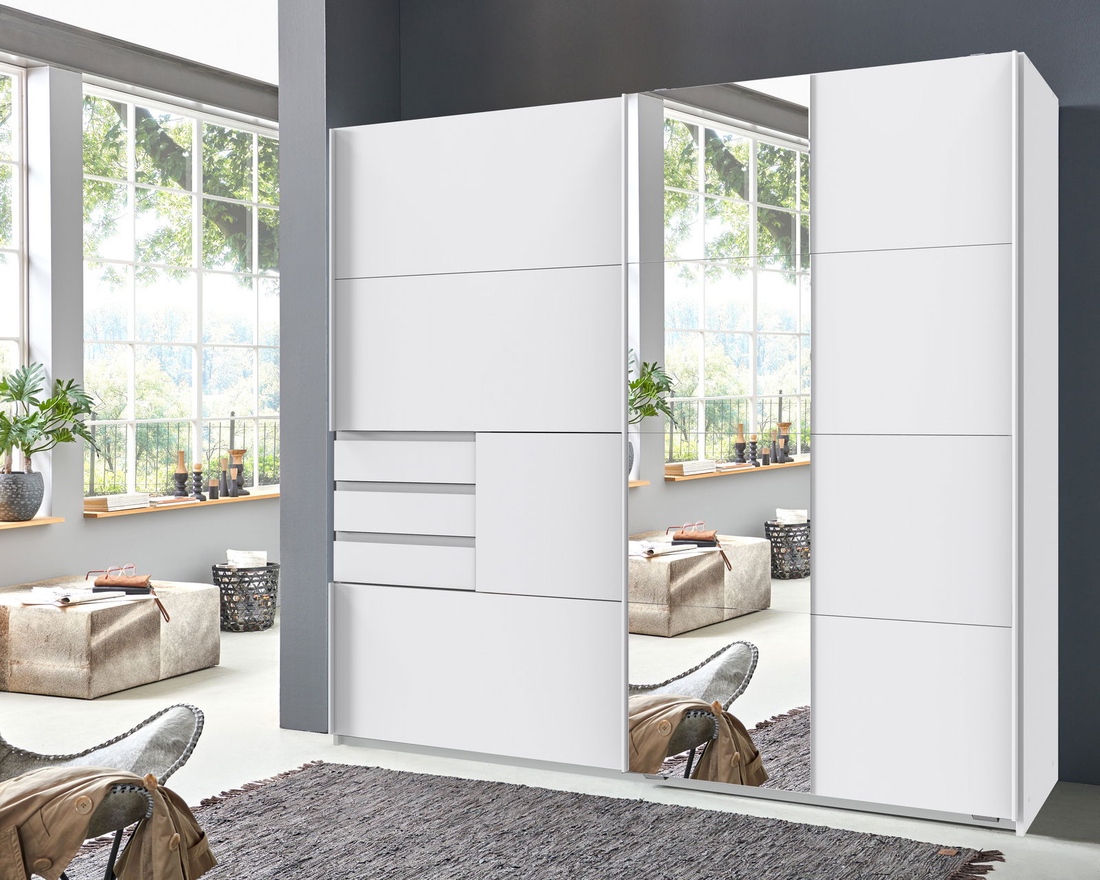 Moderner weißer Schwebetürenschrank mit Spiegel, frontale Ansicht in einem hellen Raum mit großen Fenstern.