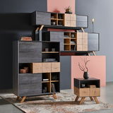 Modernes Highboard-Set in dunklem Holz mit geometrischen Mustern, bestehend aus einem großen Schrank, einem Wandregal und einem kleinen Beistelltisch, aus seitlicher Perspektive fotografiert.