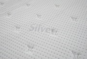 Nahaufnahme einer weißen, gesteppten Matratzenoberfläche mit dem Schriftzug 'Silver'.
