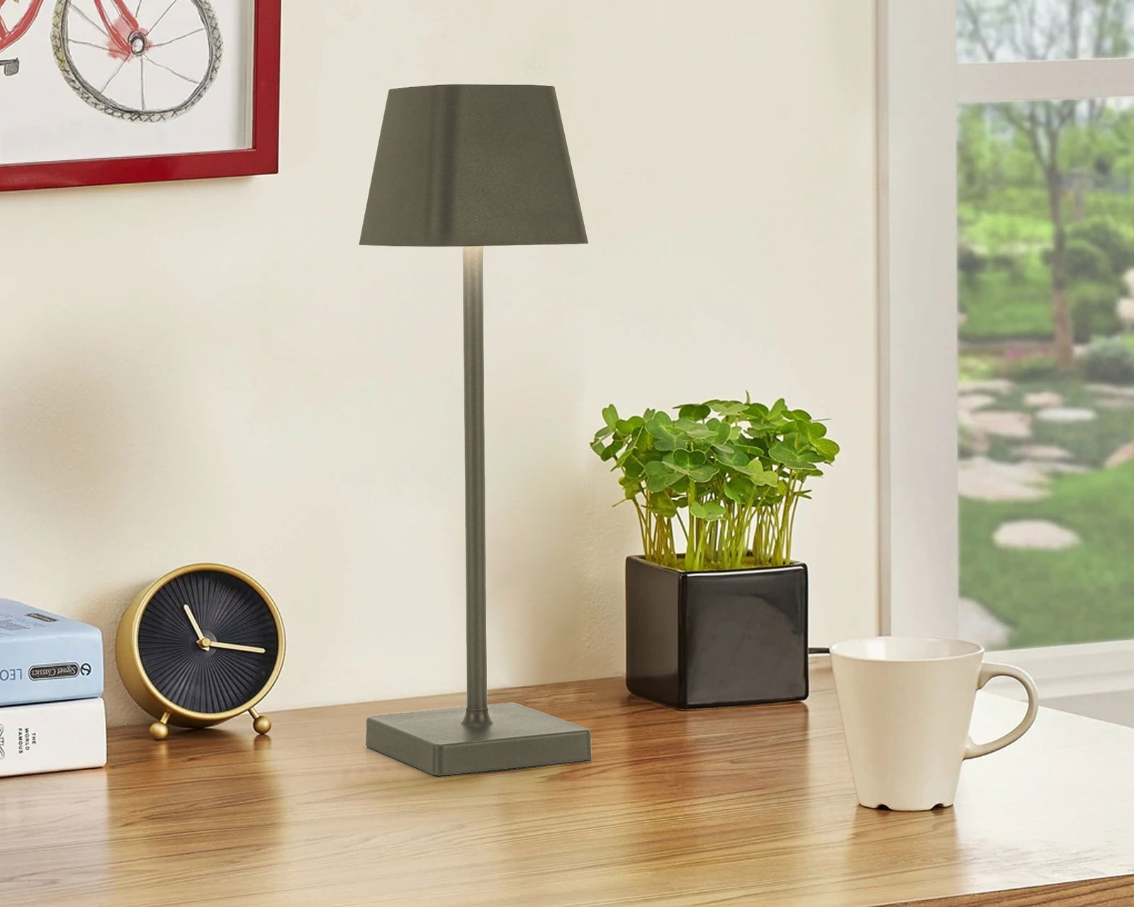 Moderne Akku-Tischleuchte in Grau auf einem Schreibtisch, seitliche Perspektive