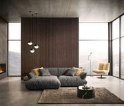 Moderne Longchairkombination in einem stilvollen Wohnzimmer mit großen Fenstern und Bergblick, aus der Frontalperspektive aufgenommen.