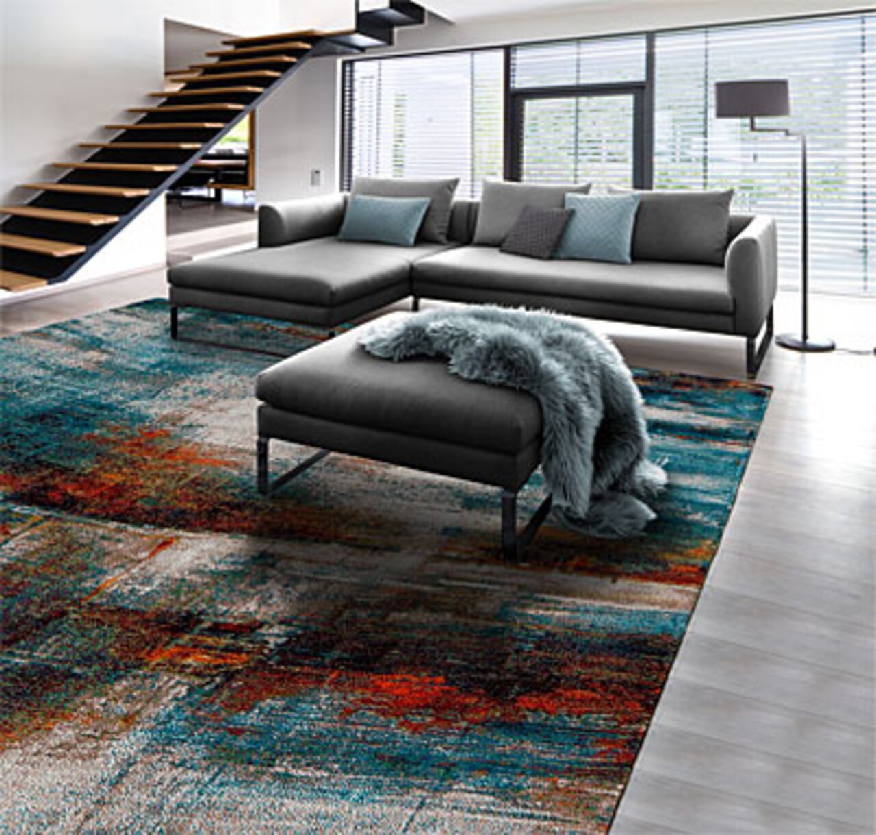 Moderne Rundecke in einem stilvollen Wohnzimmer mit Blick auf die gesamte Sitzgruppe und einem farbenfrohen Teppich.