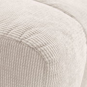 Nahaufnahme eines cremefarbenen Hockers mit gerippter Textur, seitliche Perspektive