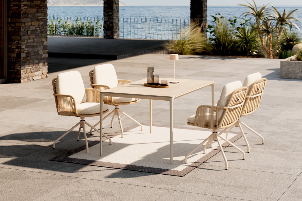 Dieter Knoll Gartentisch PATAGONA BEIGE Moderner Gartentisch mit vier stilvollen Stühlen auf einer Terrasse mit Meerblick, seitliche Perspektive.