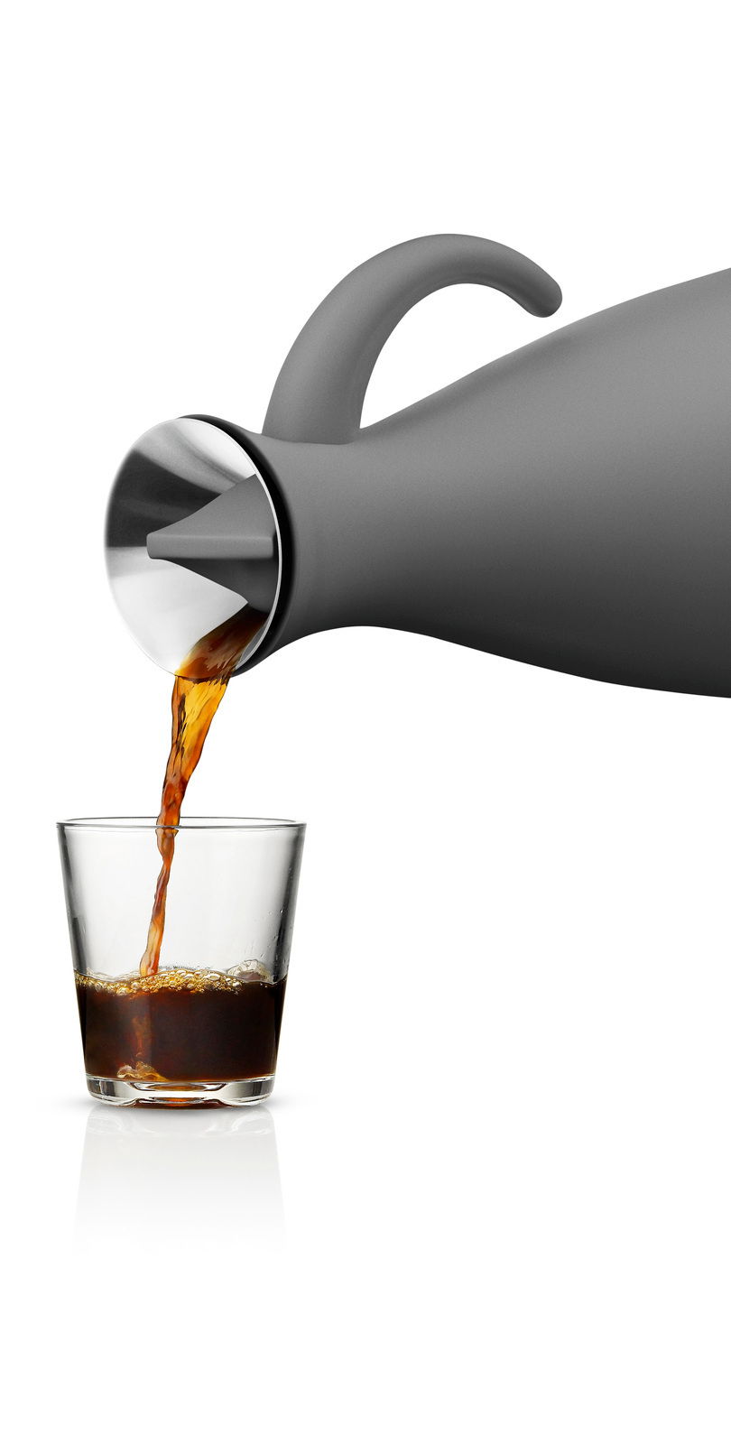Graue Isolierkanne mit gebogenem Griff, die aus seitlicher Perspektive Kaffee in ein Glas gießt.