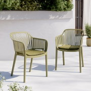 Zwei olivgrüne Outdoor-Stühle aus Kunststoff mit vertikaler Lamellen-Rückenlehne und passenden Sitzkissen auf heller Terrasse vor weißer Wand und Pflanzkasten, perspektivisch in leicht schräger Frontansicht von vorne.