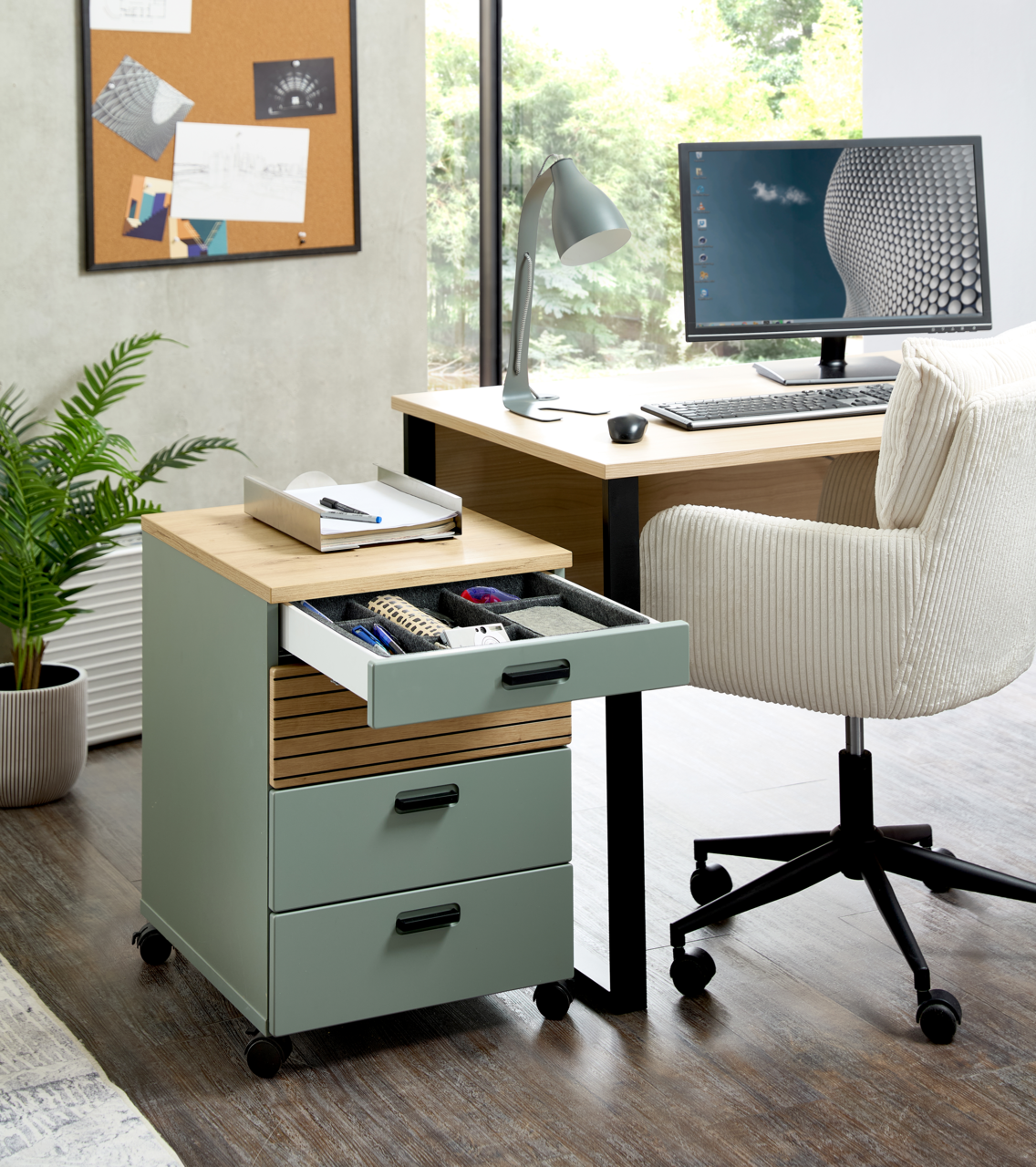 Rollcontainer mit drei Schubladen, teilweise geöffnet, in einem modernen Büro mit Schreibtisch und Stuhl, seitliche Perspektive